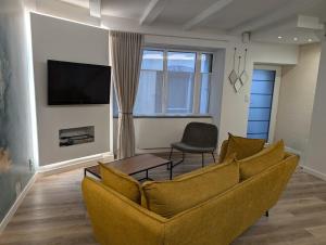 een woonkamer met een bank en een tv bij Maison chaleureuse au cœur du centre ville in Pornic