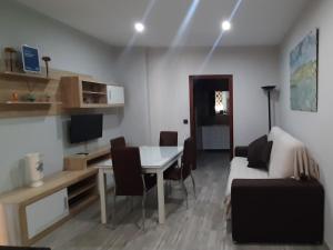 una sala de estar con una mesa y un sofá en Apartamentos Maquinista, en Puente Genil