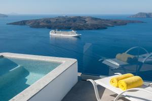 ein Kreuzfahrtschiff im Wasser mit einem Tisch und gelben Handtüchern in der Unterkunft Keti Hotel in Fira