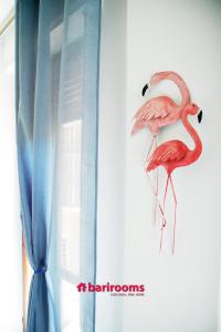 dos flamencos están parados en un lado de una ventana en BARI ROOMS Central Station, en Bari