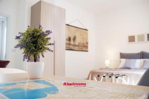 una habitación con una mesa con un jarrón con flores púrpuras en BARI ROOMS Central Station, en Bari