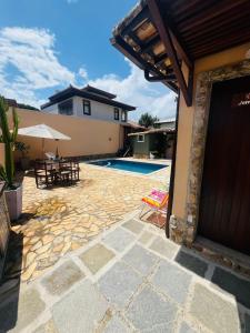 eine Terrasse mit Pool und Tisch und Stühlen in der Unterkunft Pousada Casa Manacá - Búzios in Búzios