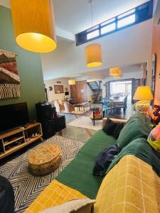 ein Wohnzimmer mit einem großen Sofa und einem Wohnzimmer in der Unterkunft Pousada Casa Manacá - Búzios in Búzios