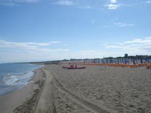 ein Strand mit Liegestühlen und Sonnenschirmen und das Meer in der Unterkunft Lina apartments A1 in Ginosa Marina
