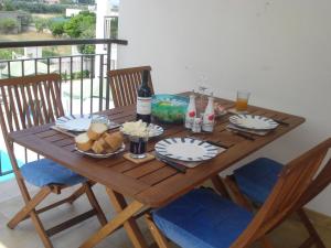 einen Holztisch mit Teller mit Speisen und einer Flasche Wein in der Unterkunft Lina apartments A1 in Ginosa Marina