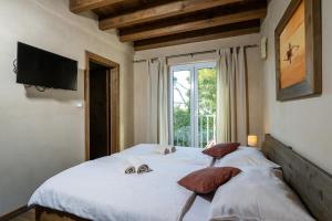 a bedroom with a large bed with a television on the wall at Villa Nocciola with Sea View, Private Pool and Sauna in Premantura +46 photos