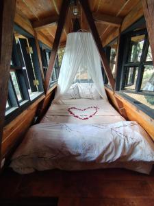a bed in a cabin with a heart drawn on it at Cabaña de madera romántica y privada in Tepetlapa