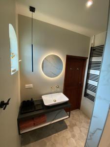 a bathroom with a sink and a mirror at Le Petit Danz in Dreumel