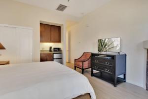 a bedroom with a white bed and a tv on a dresser at Secluded Ground Floor Studio #B in La Quinta