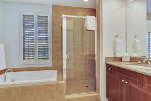 a bathroom with a shower and a tub and a sink at Secluded Ground Floor Studio #B in La Quinta