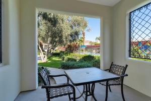 a patio with a table and two chairs and a window at Secluded Ground Floor Studio #B in La Quinta