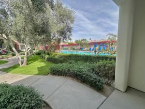 a view of a garden with a pool in the background at Secluded Ground Floor Studio #B in La Quinta +9 photos