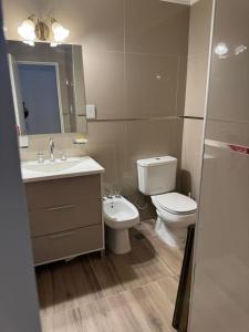 a bathroom with a toilet and a sink and a mirror at dpto italia in Comodoro Rivadavia