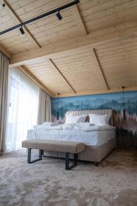 a bedroom with a large bed and a wooden ceiling at Chalet Pamporovo in Pamporovo