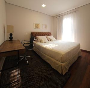 a bedroom with a bed and a desk and a window at Casa Garay Hotel 658 in Asuncion