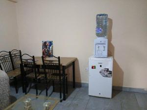 a room with a table and a refrigerator with a bottle on top at Airbnb in Mwea town in Thiba