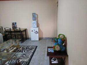 a living room with a refrigerator and a table at Airbnb in Mwea town in Thiba