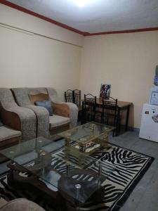 a living room with a couch and a glass table at Airbnb in Mwea town in Thiba