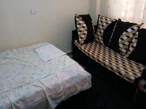 a bedroom with a bed and a couch at Airbnb in Mwea town in Thiba +4 photos