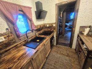 uma cozinha com um balcão de madeira e um lavatório em Drevenička Zázrivá Terchová em Zázrivá mais 24 fotografias