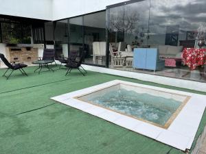 a hot tub on a green floor next to a building at Finca Bellavista in Villeta +17 photos