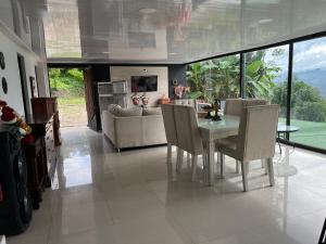 a dining room with a table and chairs and a couch at Finca Bellavista in Villeta