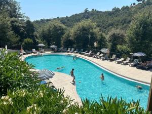a large swimming pool with people in the water at Bungalow à Nice in Cagnes-sur-Mer