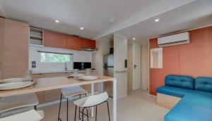 a kitchen with a counter and blue chairs in it at Bungalow à Nice in Cagnes-sur-Mer