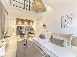 a living room with a white couch and a table at Hyper Centre - Charming duplex - Luxury - Reversible air conditioning - 10 mins from Place MASSENA in Nice