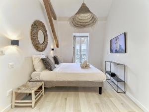 a white bedroom with a bed and a couch at Hyper Centre - Charming duplex - Luxury - Reversible air conditioning - 10 mins from Place MASSENA in Nice