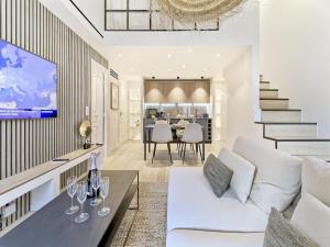 a living room with a white couch and a tv at Hyper Centre - Charming duplex - Luxury - Reversible air conditioning - 10 mins from Place MASSENA in Nice