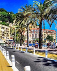a city street with palm trees and buildings at Hyper Centre - Charming duplex - Luxury - Reversible air conditioning - 10 mins from Place MASSENA in Nice
