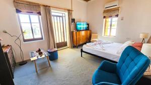 a bedroom with a bed and a chair and a tv at Traditional House Aggeliki in Kounoupidhianá