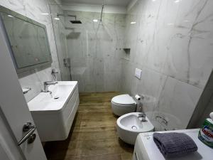a white bathroom with a sink and a toilet at Veranda Center Apartment in Tirana +32 photos