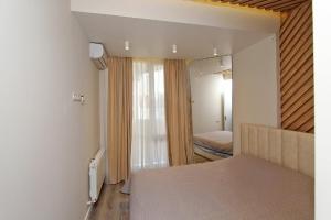 a bedroom with a bed and a bedroom with a window at Stylish Modern 1 BEDROOM by REPUBLIC SQUARE ,CITY CENTER in Yerevan