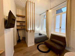 a small living room with a couch and a bed at LE VOLTA - Appartement - Centre ville Calais in Calais