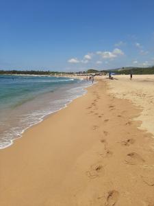 a beach with footprints in the sand and the ocean at Ελαια in Marathopolis