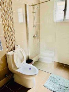 a bathroom with a toilet with the lid up at hermosa casa en las orquídeas la romana in La Romana
