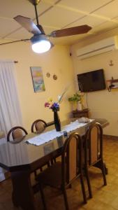 a dining room table with chairs and a ceiling fan at la casa de la abuela in San Pedro