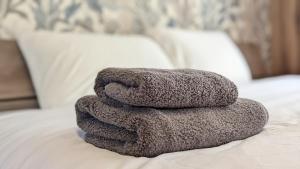 a pile of towels sitting on top of a bed at Yonagunijima Hotel Munbu Stay Kukomae - Vacation STAY 87337v in Sonai