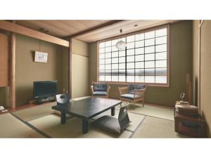 a living room with a coffee table and a large window at Ryokan Akebono - Vacation STAY 91891v in Saga