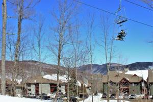 a person is riding on a ski lift in the snow at Sunrise Timberline K8 in Killington