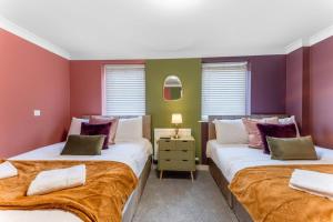 two beds in a room with purple and green walls at Harland Haven Spacious 4br House In Ipswich in Ipswich