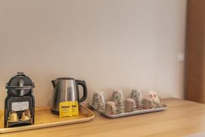 a kitchen counter with a coffee maker and coffee cups at Guest house in Montévrain
