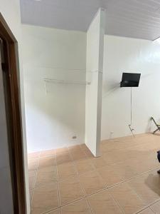 a room with a white wall and a tiled floor at Apartamento Quepos in Quepos