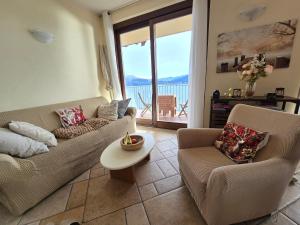 a living room with two couches and a table at Lago Maggiore - Traumbalkon mit Seeblick & Pool und 2 SZ in Oggebbio