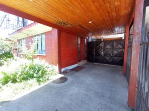 een garage met een houten garagedeur met een houten plafond bij Hospedaje Pensión Ely Habitación doble in Temuco