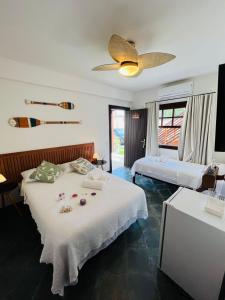 ein Schlafzimmer mit zwei Betten und einem Deckenventilator in der Unterkunft Pousada Casa Manacá - Búzios in Búzios + 50 Fotos