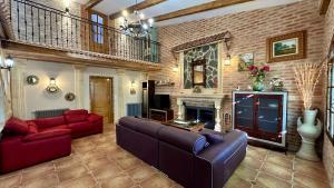 a living room with red couches and a fireplace at Finca El Rosario in Casas de los Pinos