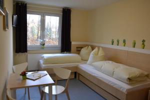a hotel room with two beds and a table and a table sidx sidx at Villa Ephraim in Görlitz